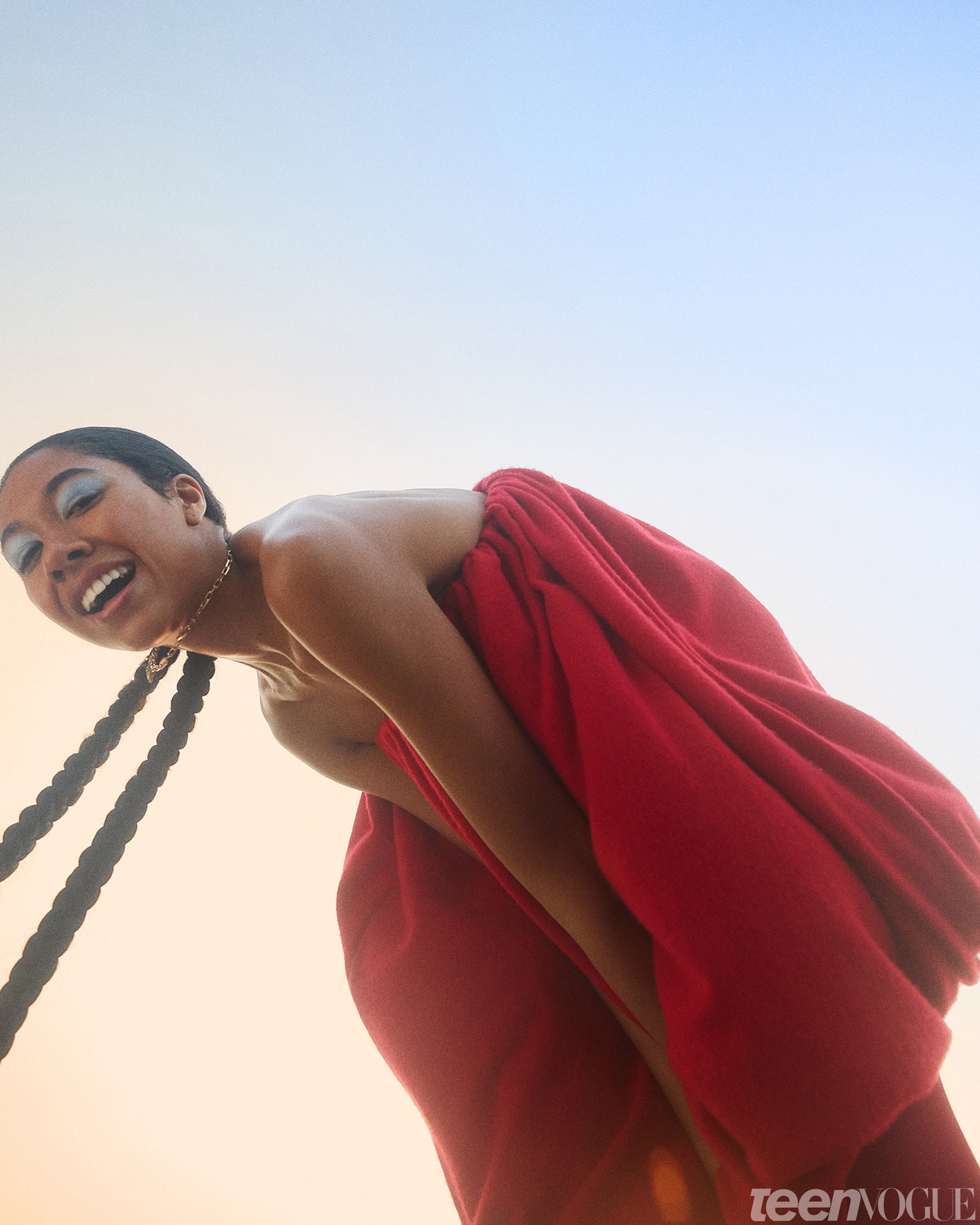 Aoki Lee Simmons standing in red balloon dress against the sky.