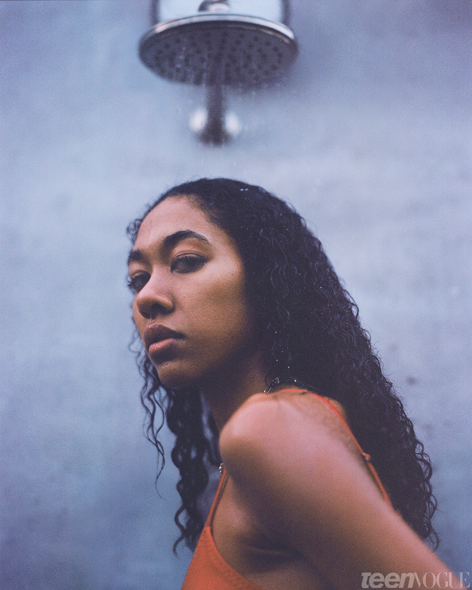 Aoki Lee Simmons standing under a shower head.