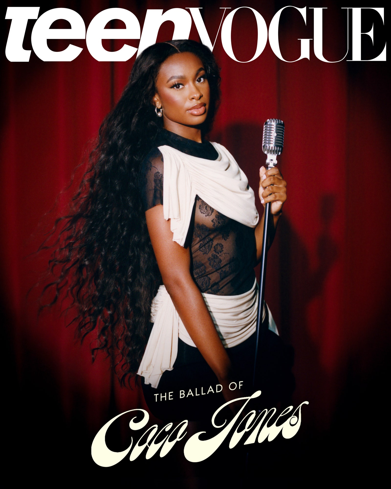 Coco Jones wearing black and white holding a microphone in front of a red theater curtain