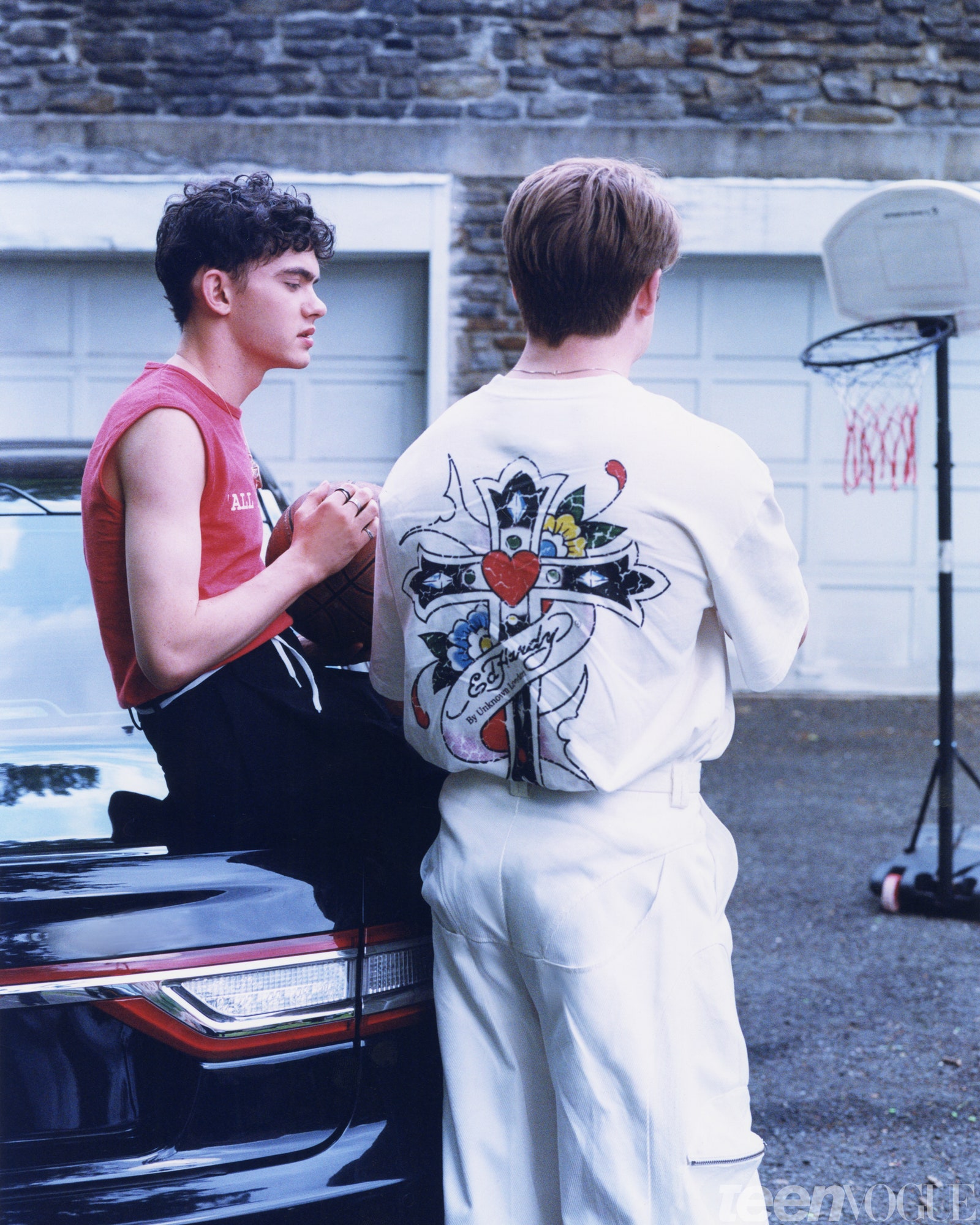 Joe Locke and Kit Connor standing in a driveway.