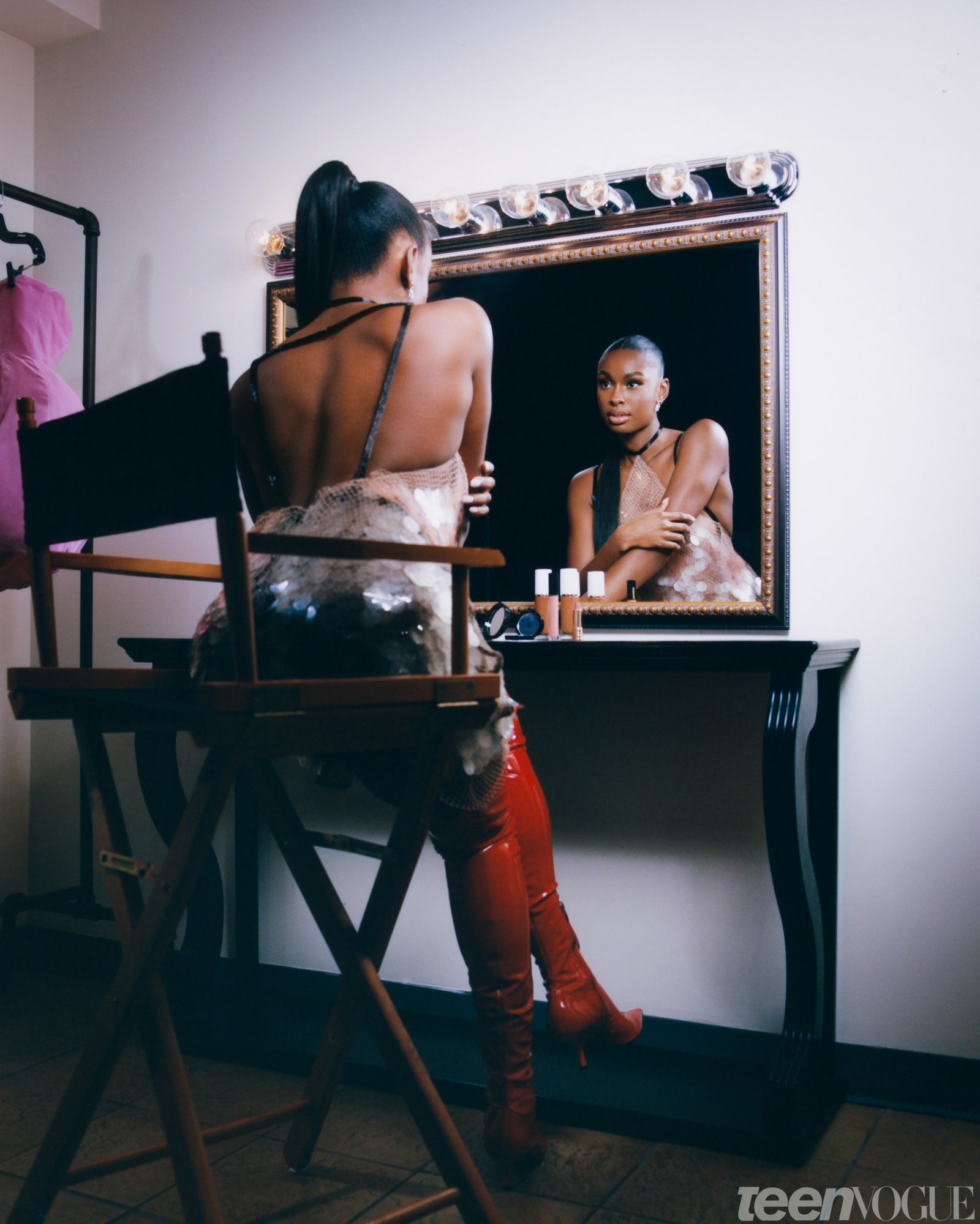 Coco Jones sitting at a dressing room vanity mirror